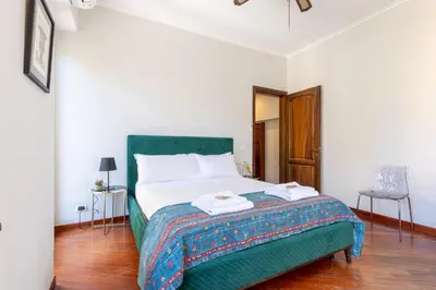 a bedroom with a green bed and a window at Calm Home - Center Rome in Rome