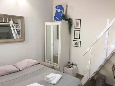 a white room with a bed and a staircase at Bright and cosy appartament near the city center in Rome