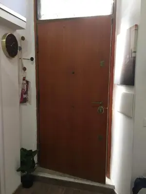a brown door in a room with a window at Bright and cosy appartament near the city center in Rome