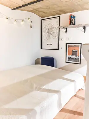 a bedroom with a white bed and a blue chair at Bright and cosy appartament near the city center in Rome
