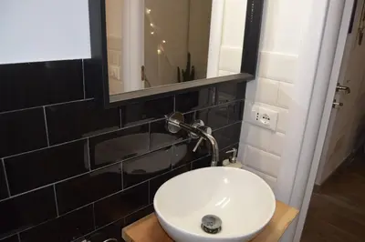 a bathroom with a white sink and a mirror at Bright and cosy appartament near the city center in Rome