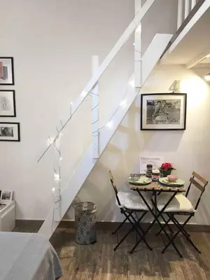 a dining room with a table and a staircase at Bright and cosy appartament near the city center in Rome
