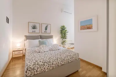 a white bedroom with a bed with pillows on it at CS Central Station Termini Monti Apartment in Rome