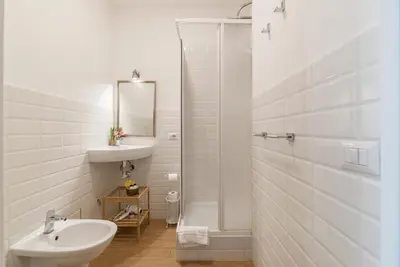 a white bathroom with a sink and a shower at CS Central Station Termini Monti Apartment in Rome