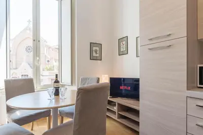 a dining room with a table and chairs and a television at CS Central Station Termini Monti Apartment in Rome