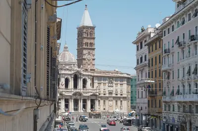 a busy city street with a building with a clock tower at CS Central Station Termini Monti Apartment in Rome