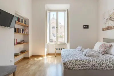 a bedroom with a bed and a large window at CS Central Station Termini Monti Apartment in Rome
