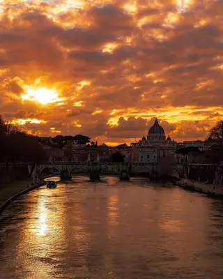 a sunset over a river with a bridge at Intero appartamento Marconi in Rome