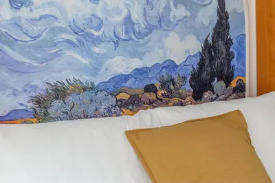 a painting hanging on a wall above a bed at iFlat Vatican Comfortable & Peaceful Retreat in Rome