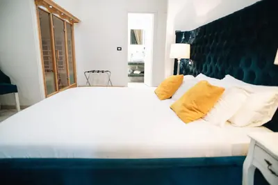 a large white bed with two yellow pillows on it at Escape Suite Guest House - Ca Domus Collection in Rome