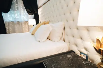a bedroom with a white bed with a large headboard at Escape Suite Guest House - Ca Domus Collection in Rome