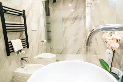 a bathroom with a sink and a toilet and a mirror at Escape Suite Guest House - Ca Domus Collection in Rome