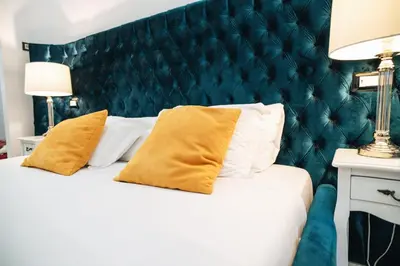 a white bed with yellow pillows and a green headboard at Escape Suite Guest House - Ca Domus Collection in Rome