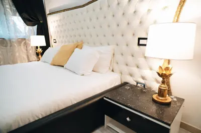 a bedroom with a white tufted bed and a table with a lamp at Escape Suite Guest House - Ca Domus Collection in Rome