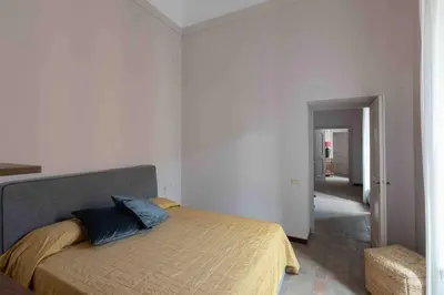 a bedroom with a bed with two blue pillows on it at Luxury house Empire 96 in Rome