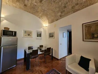 a living room with a table and a couch at Be Your Home - Spritz Apartment in Rome