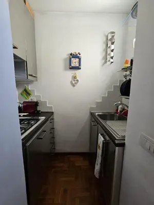 a kitchen with a sink and a clock on the wall at Be Your Home - Spritz Apartment in Rome