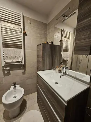 a bathroom with a sink and a toilet and a mirror at Be Your Home - Spritz Apartment in Rome