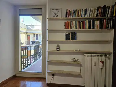 a room with a book shelf filled with books at Be Your Home - Spritz Apartment in Rome