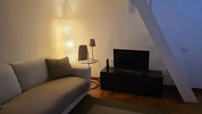 a living room with a couch and a television at Be Your Home - Spritz Apartment in Rome