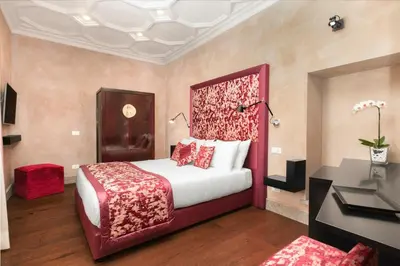 a bedroom with a large bed with a red headboard at èROMA - PANTHEON LUXURY SUITE in Rome
