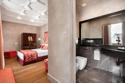 a hotel room with a bed and a bathroom at èROMA - PANTHEON LUXURY SUITE in Rome