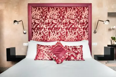 a bedroom with a bed with a red headboard at èROMA - PANTHEON LUXURY SUITE in Rome