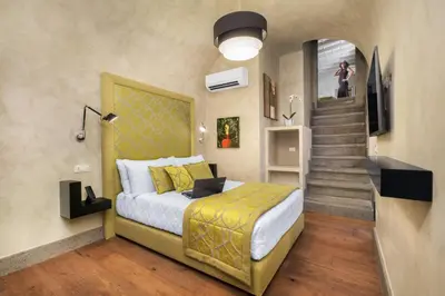 a bedroom with a large bed and a staircase at èROMA - PANTHEON LUXURY SUITE in Rome