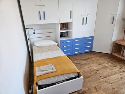 a small room with a bunk bed and white cabinets at Luminoso attico con terrazza in Rome