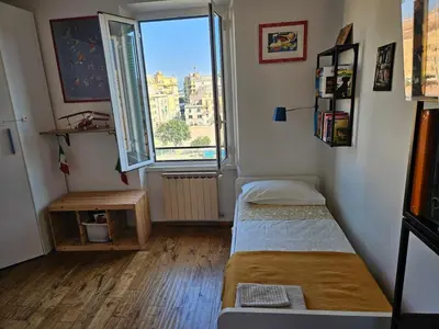 a small room with a bed and a window at Luminoso attico con terrazza in Rome