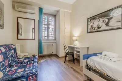 a bedroom with a bed and a desk and a chair at Elegant flat in front of Vatican museum in Rome