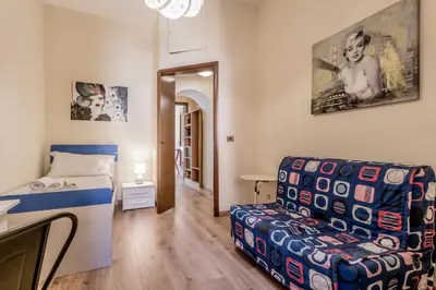 a small bedroom with a bed and a chair at Elegant flat in front of Vatican museum in Rome