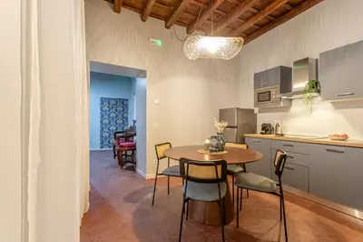 a kitchen and dining room with a table and chairs at Ambra - Liberty Apartment at the Imperial Forums in Rome