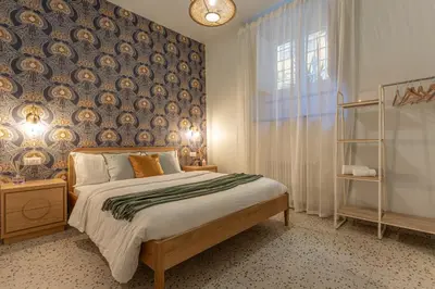 a bedroom with a bed with a blue and gold wallpaper at Ambra - Liberty Apartment at the Imperial Forums in Rome