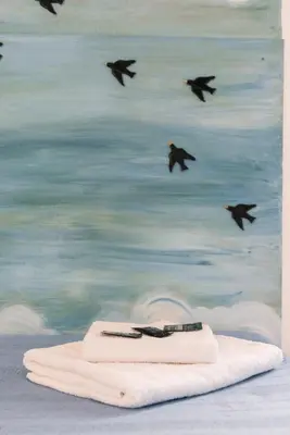 a painting of a towel with birds flying over the ocean at Grande appartamento a Trastevere in Rome