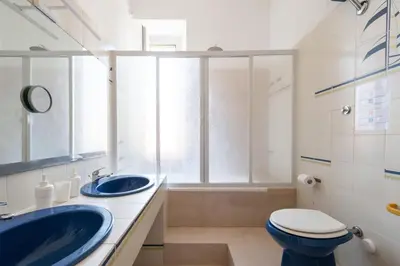 a bathroom with two sinks and a toilet and a window at Grande appartamento a Trastevere in Rome