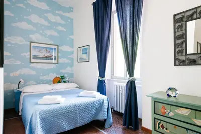 a bedroom with a bed with blue curtains and a window at Grande appartamento a Trastevere in Rome
