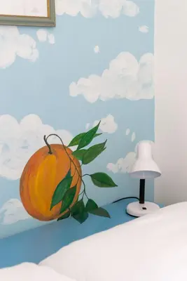 a painting of an orange on a bed with a lamp at Grande appartamento a Trastevere in Rome