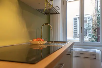 a kitchen with a sink and a bowl of fruit on the counter at Giada - Charming Apartment at the Imperial Forums in Rome