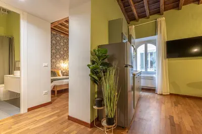 a living room with a refrigerator and a bedroom at Giada - Charming Apartment at the Imperial Forums in Rome