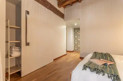 a small room with a bed and a closet at Giada - Charming Apartment at the Imperial Forums in Rome