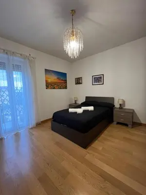 a bedroom with a black bed and a chandelier at Casa Conca D Oro in Rome
