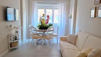 a living room with a table and chairs and a couch at Appartamento Aurelio in Rome