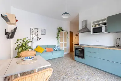 a kitchen and living room with a blue couch at Grazioso appartamento a Roma San Paolo in Rome