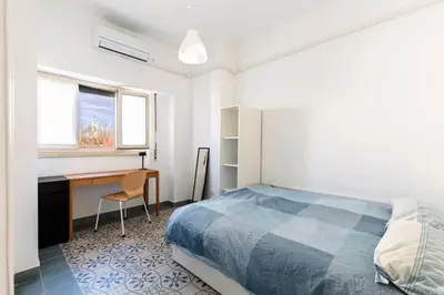 a bedroom with a bed and a desk and a window at Grazioso appartamento a Roma San Paolo in Rome