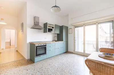 a kitchen with blue cabinets and a table with chairs at Grazioso appartamento a Roma San Paolo in Rome