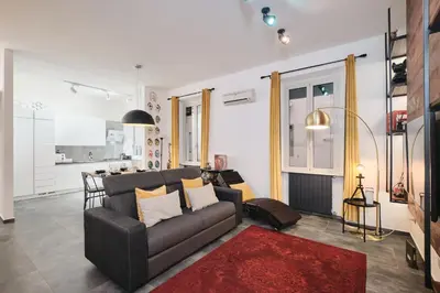 a living room with a couch and a kitchen at Elegante appartamento a pochi passi dal Centro in Rome