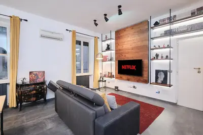 a living room with a couch and a tv on a wall at Elegante appartamento a pochi passi dal Centro in Rome