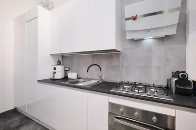 a white kitchen with a sink and a stove at Elegante appartamento a pochi passi dal Centro in Rome