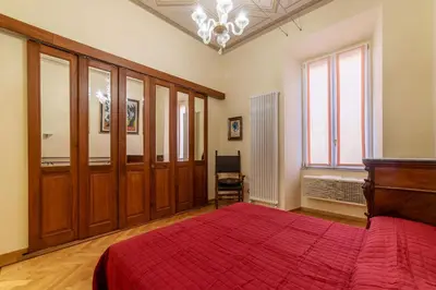 a bedroom with a bed with a red blanket at GuestHost - Historic Apartment in Sallustiano in Rome